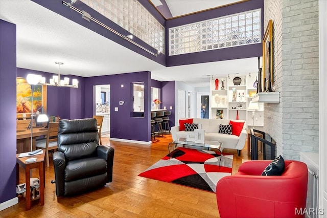 2 Tanewood Ct, Belleville, IL 62223 - living area with a chandelier, wood finished floors, a fireplace, and a towering ceiling