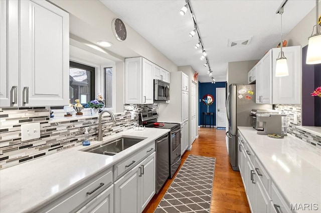 2 Tanewood Ct, Belleville, IL 62223 - kitchen with appliances with stainless steel finishes, track lighting, white cabinetry, tasteful backsplash, and light countertops