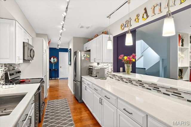 2 Tanewood Ct, Belleville, IL 62223 - kitchen with stainless steel appliances, rail lighting, white cabinetry, and decorative backsplash