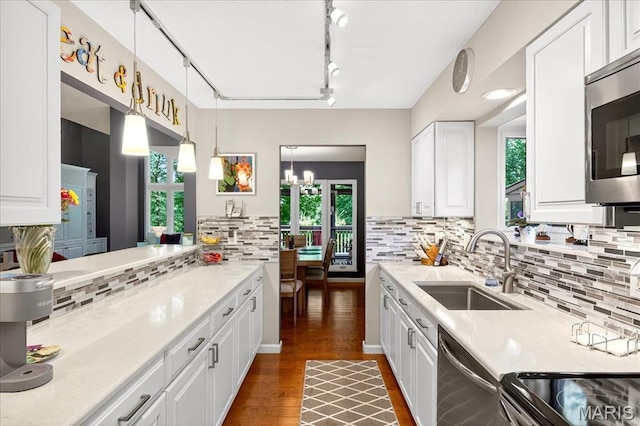 2 Tanewood Ct, Belleville, IL 62223 - kitchen with appliances with stainless steel finishes, tasteful backsplash, light countertops, wood finished floors, and white cabinetry