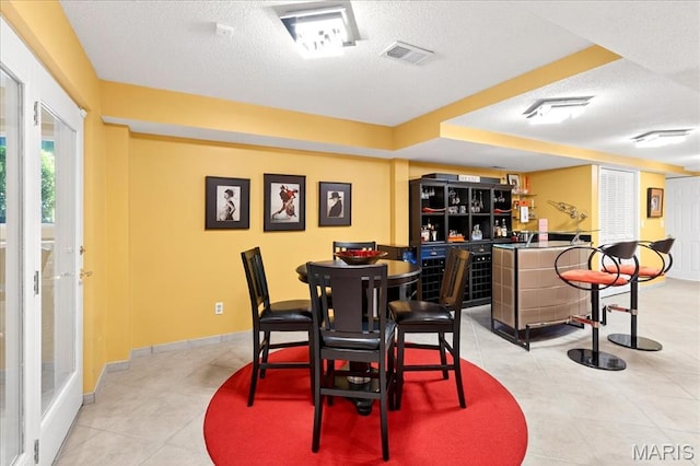 2 Tanewood Ct, Belleville, IL 62223 - dining area with a bar, a textured ceiling, and light tile patterned floors