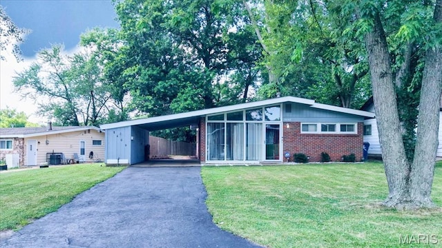 8400 Chalons Ct, Berkeley, MO 63134 - mid-century modern home with brick siding, asphalt driveway, a front yard, and an attached carport