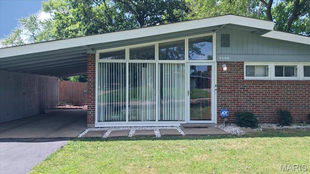 8400 Chalons Ct, Berkeley, MO 63134 - view of property exterior with brick siding, driveway, a lawn, and an attached carport