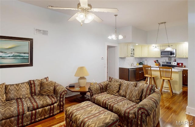 515 E S Ave, Greenville, IL 62246 - living room with ceiling fan, wood finished floors, a chandelier, and a high ceiling