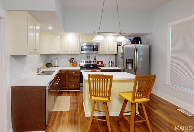 515 E S Ave, Greenville, IL 62246 - kitchen featuring appliances with stainless steel finishes, dark wood-type flooring, light countertops, a center island, and a breakfast bar area