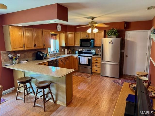 8 E 11th St, Washington, MO 63090 - kitchen with stainless steel appliances, light countertops, light wood-style flooring, and tasteful backsplash
