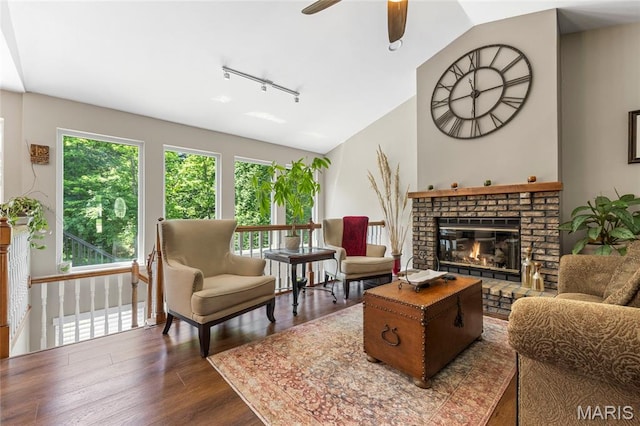 600 Emerald Meadows Ct, Saint Charles, MO 63304 - living room with rail lighting, healthy amount of natural light, a brick fireplace, dark wood finished floors, and vaulted ceiling