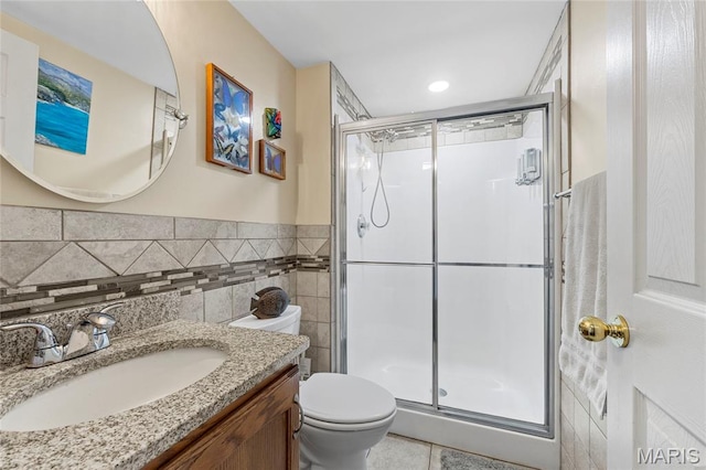 600 Emerald Meadows Ct, Saint Charles, MO 63304 - bathroom featuring vanity, a shower stall, tile walls, tile patterned floors, and wainscoting