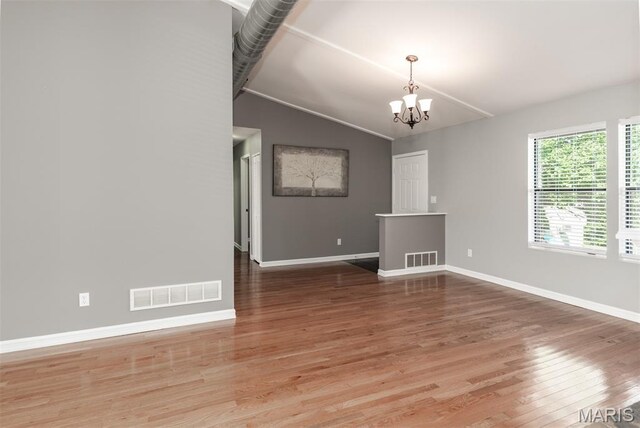 1409 Castle Mill Dr, Arnold, MO 63010 - spare room featuring lofted ceiling, a chandelier, and light wood-style flooring