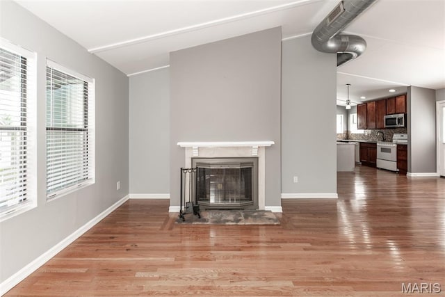 1409 Castle Mill Dr, Arnold, MO 63010 - unfurnished living room with a fireplace with flush hearth and light wood-type flooring