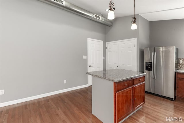1409 Castle Mill Dr, Arnold, MO 63010 - kitchen with stainless steel refrigerator with ice dispenser, wood finished floors, decorative light fixtures, light stone countertops, and a towering ceiling