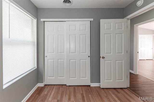 1409 Castle Mill Dr, Arnold, MO 63010 - unfurnished bedroom with a closet, wood finished floors, and multiple windows