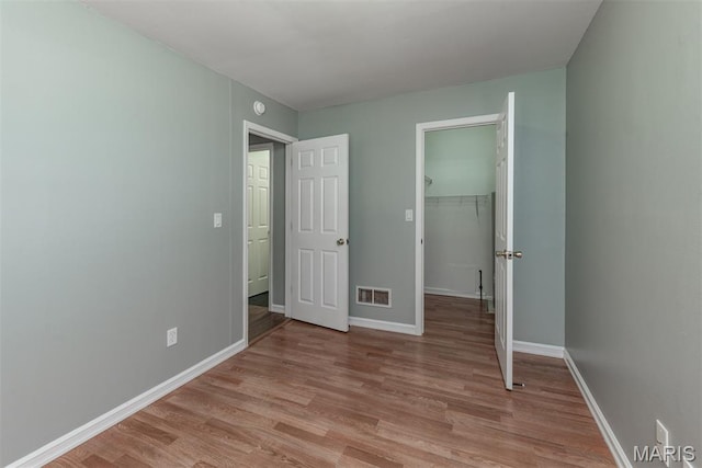 1409 Castle Mill Dr, Arnold, MO 63010 - unfurnished bedroom featuring light wood-style floors and a spacious closet