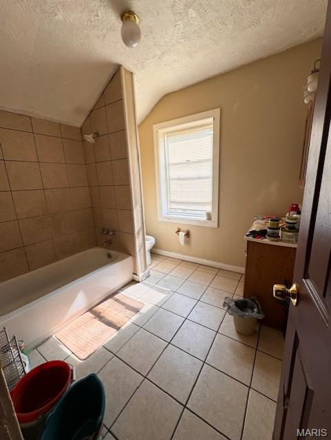 4202 Gano Ave, Saint Louis, MO 63107 - bathroom featuring tile patterned floors, vaulted ceiling, a textured ceiling, and tub / shower combination