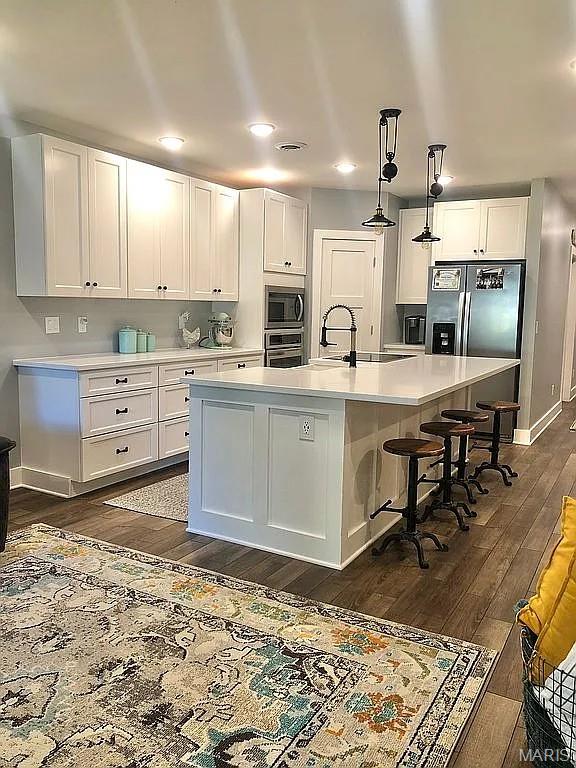 1106 Palmer Pl, Imperial, MO 63052 - kitchen featuring appliances with stainless steel finishes, light countertops, dark wood-style floors, white cabinets, and recessed lighting