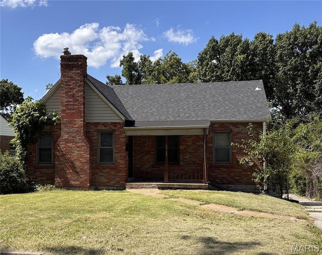 6765 Kenwood Dr, Northwoods, MO 63121 - view of front facade featuring a front yard, a porch, brick siding, and a chimney