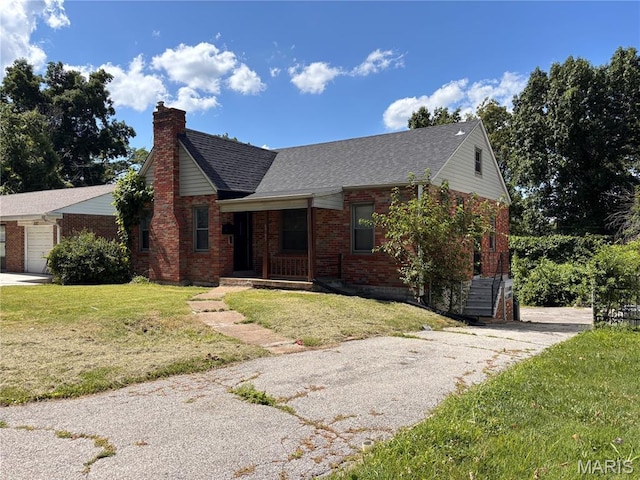 6765 Kenwood Dr, Northwoods, MO 63121 - view of front of house featuring brick siding, a chimney, a front yard, asphalt driveway, and roof with shingles