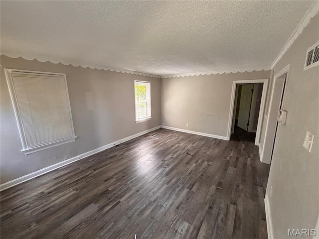 6765 Kenwood Dr, Northwoods, MO 63121 - unfurnished room featuring a textured ceiling and dark wood-style flooring