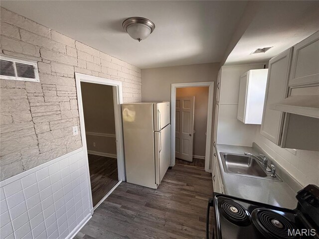 6765 Kenwood Dr, Northwoods, MO 63121 - kitchen with freestanding refrigerator, black range with electric stovetop, dark wood-style floors, and light countertops