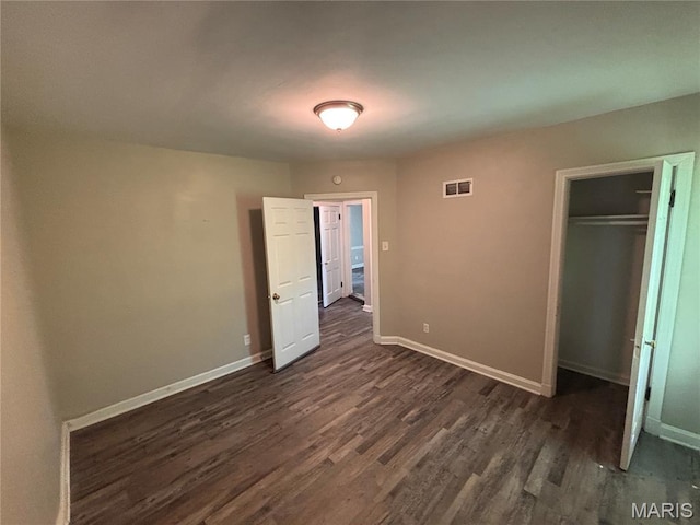 6765 Kenwood Dr, Northwoods, MO 63121 - unfurnished bedroom featuring dark wood-style floors and a closet