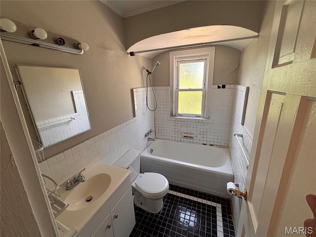 6765 Kenwood Dr, Northwoods, MO 63121 - bathroom featuring tile patterned floors, vanity, shower / bathtub combination, tile walls, and a wainscoted wall