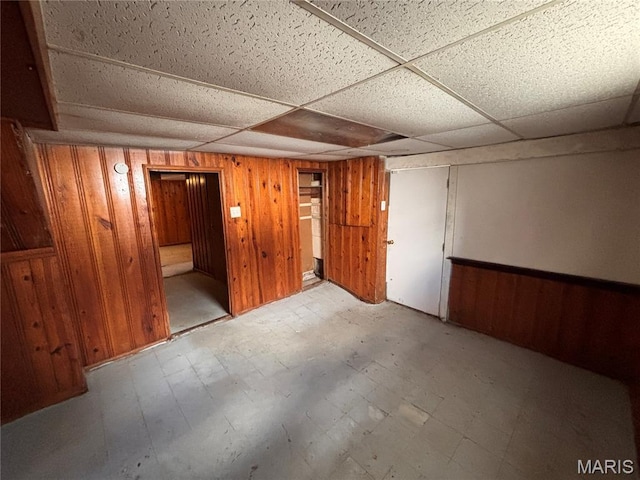 6765 Kenwood Dr, Northwoods, MO 63121 - finished below grade area featuring tile patterned floors, wooden walls, and a paneled ceiling