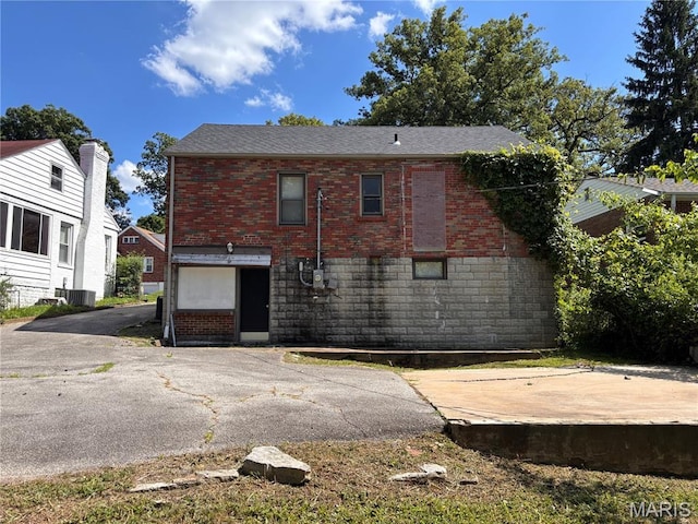 6765 Kenwood Dr, Northwoods, MO 63121 - view of side of property featuring brick siding and a central AC unit