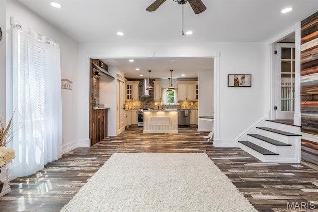 712 Maple St, Hillsboro, MO 63050 - kitchen featuring cream cabinetry, wall chimney range hood, appliances with stainless steel finishes, dark wood finished floors, and a center island