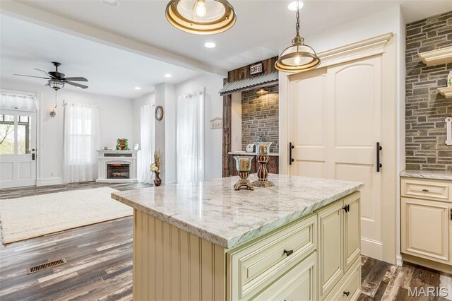 712 Maple St, Hillsboro, MO 63050 - kitchen featuring cream cabinets, a glass covered fireplace, dark wood-style floors, a ceiling fan, and recessed lighting