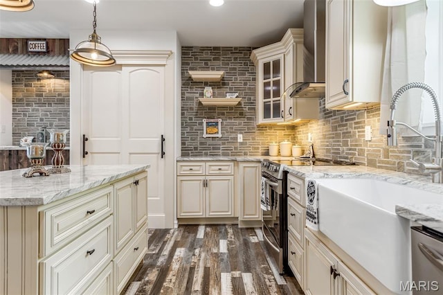 712 Maple St, Hillsboro, MO 63050 - kitchen with wall chimney exhaust hood, appliances with stainless steel finishes, cream cabinetry, dark wood-type flooring, and glass insert cabinets