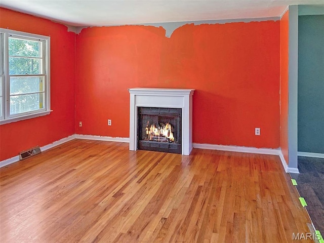 112 W Thurman St, Columbia, MO 65202 - unfurnished living room with wood finished floors and a lit fireplace