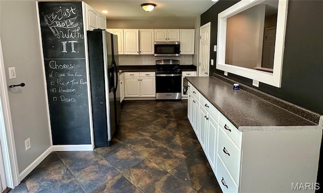 7 Oxbow Rd, Saint Peters, MO 63376 - kitchen featuring stainless steel appliances, dark countertops, white cabinetry, backsplash, and stone finish flooring