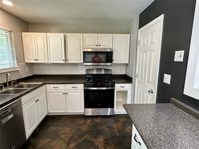 7 Oxbow Rd, Saint Peters, MO 63376 - kitchen featuring appliances with stainless steel finishes, dark countertops, white cabinetry, and decorative backsplash