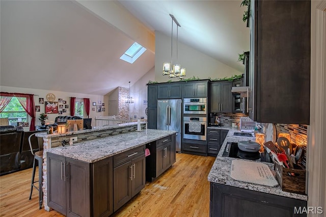 532 Fairfield Valley Rd, Pacific, MO 63069 - kitchen featuring a skylight, open floor plan, a breakfast bar area, a chandelier, and stainless steel appliances