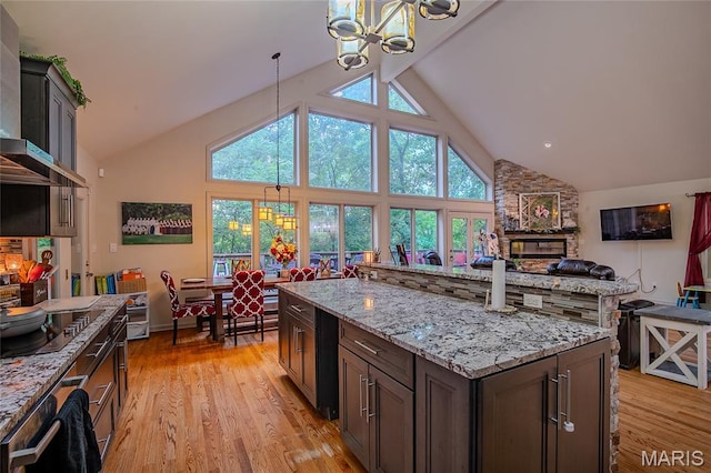 532 Fairfield Valley Rd, Pacific, MO 63069 - kitchen with a chandelier, wall chimney range hood, high vaulted ceiling, light wood finished floors, and black electric cooktop