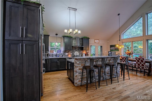 532 Fairfield Valley Rd, Pacific, MO 63069 - kitchen with a chandelier, wall chimney range hood, a breakfast bar, light stone counters, and high vaulted ceiling