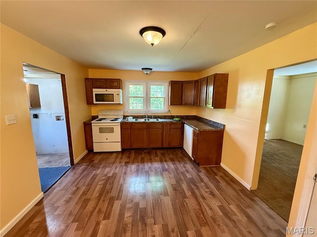 504 Wolfe St, Potosi, MO 63664 - kitchen featuring white appliances, dark wood-style floors, dark countertops, and brown cabinetry