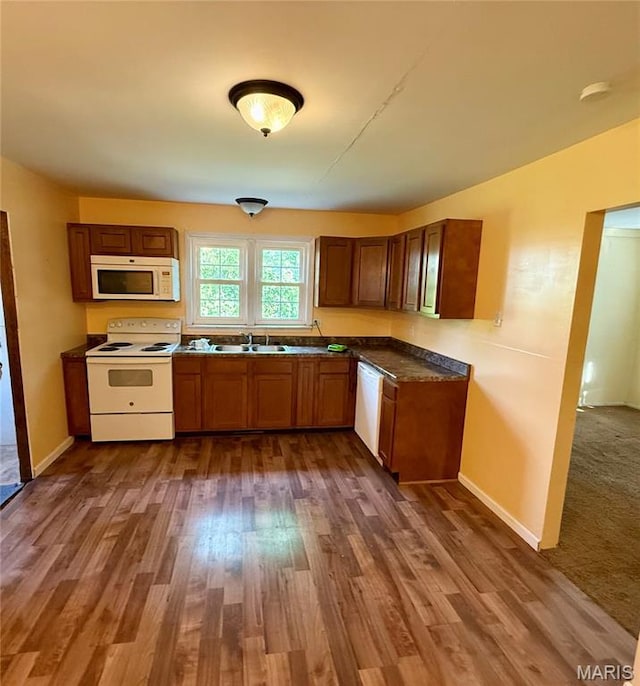 504 Wolfe St, Potosi, MO 63664 - kitchen with white appliances, dark wood-style floors, dark countertops, and brown cabinetry