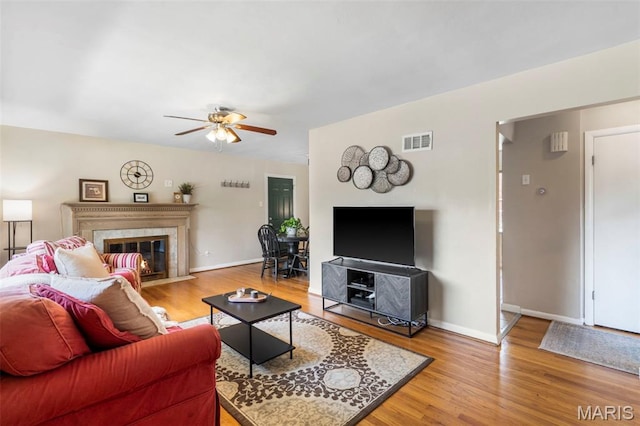 346 Madison Ave, Saint Louis, MO 63119 - living room with light wood finished floors, a ceiling fan, and a high end fireplace