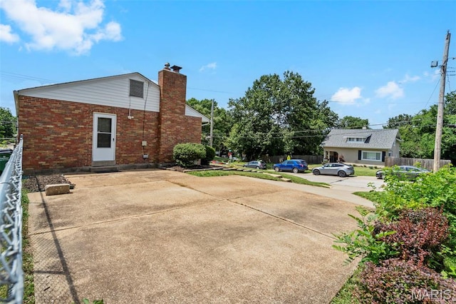 346 Madison Ave, Saint Louis, MO 63119 - rear view of property featuring brick siding, a chimney, concrete driveway, and entry steps