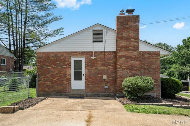 346 Madison Ave, Saint Louis, MO 63119 - back of property featuring a chimney, brick siding, and a patio
