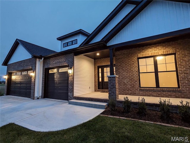 8748 Wendell Creek Dr, Saint Jacob, IL 62281 - view of front of home featuring driveway, an attached garage, brick siding, covered porch, and crawl space