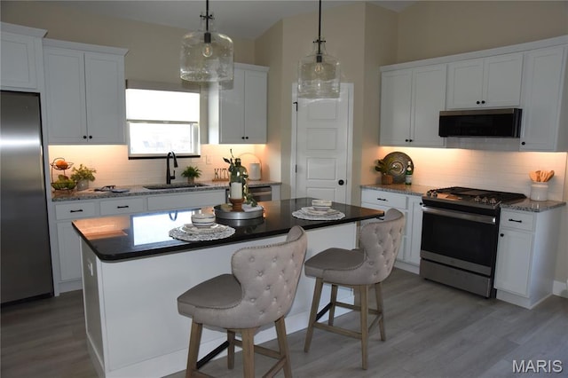 8748 Wendell Creek Dr, Saint Jacob, IL 62281 - kitchen with appliances with stainless steel finishes, tasteful backsplash, wood finished floors, and a kitchen island