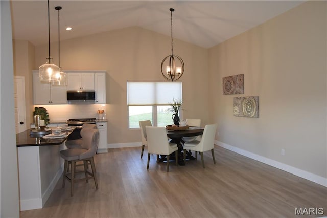 8748 Wendell Creek Dr, Saint Jacob, IL 62281 - dining area featuring a chandelier, light wood-style floors, and high vaulted ceiling