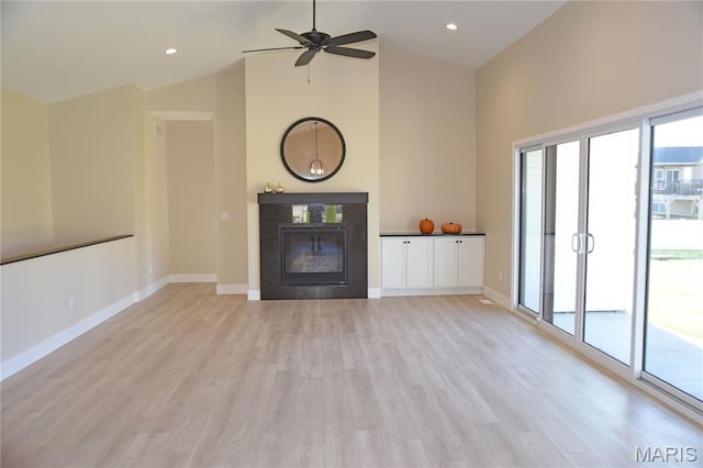 8748 Wendell Creek Dr, Saint Jacob, IL 62281 - unfurnished living room with light wood-style flooring, ceiling fan, high vaulted ceiling, and a tile fireplace