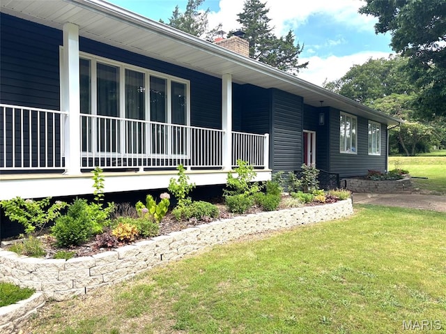 14875 County Road 2310, St James, MO 65559 - view of home's exterior with a chimney, a lawn, and covered porch