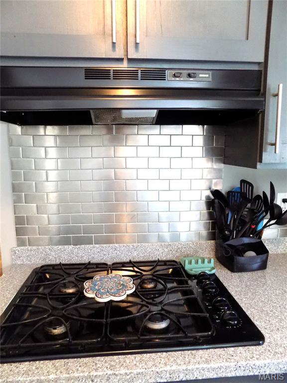 14875 County Road 2310, St James, MO 65559 - kitchen view of black gas cooktop, tasteful backsplash, light countertops, and under cabinet range hood