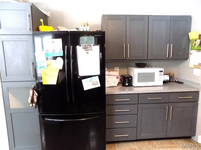 14875 County Road 2310, St James, MO 65559 - kitchen featuring freestanding refrigerator, white microwave, and light countertops