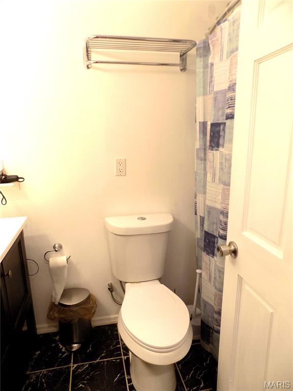 14875 County Road 2310, St James, MO 65559 - bathroom with marble look tiles, vanity, and a shower with curtain