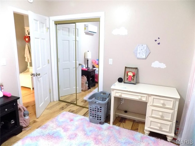 14875 County Road 2310, St James, MO 65559 - bedroom with a wall unit AC, wood finished floors, and a closet